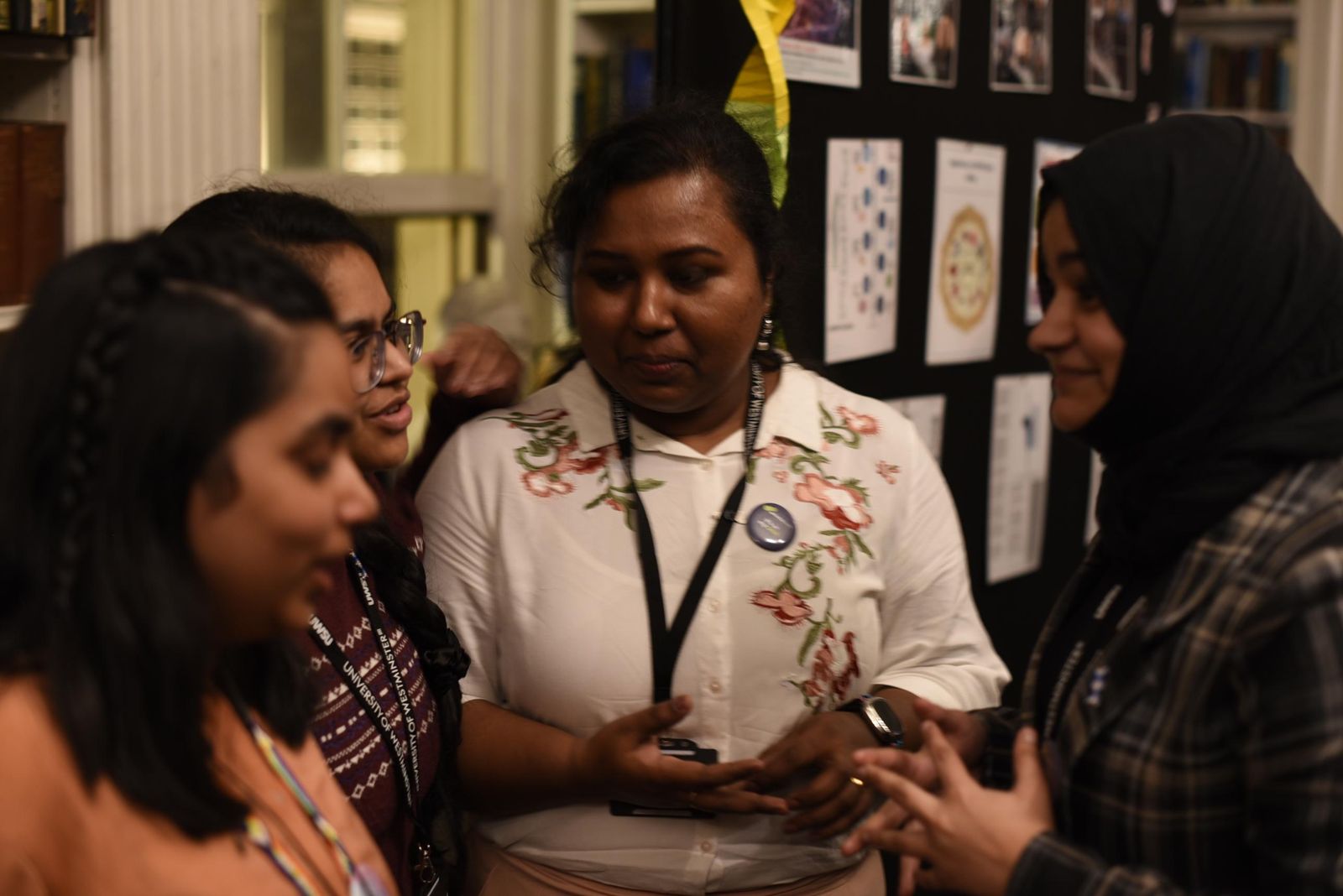 Subaiba in conversation with a group of people beside the display board