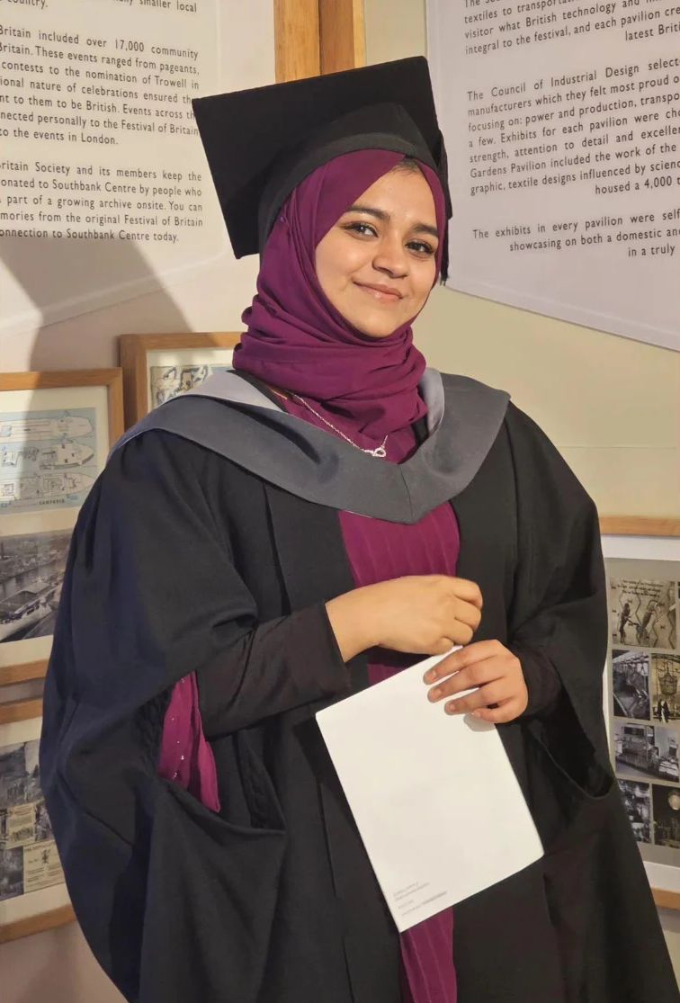 Subaiba in graduation gown and cap, holding a certificate
